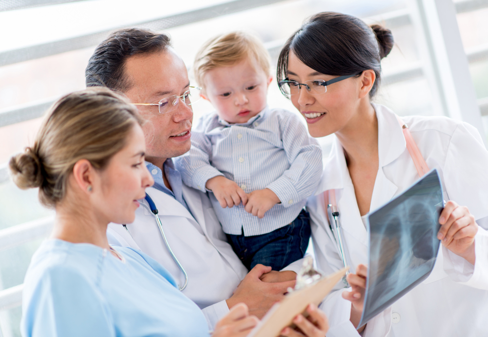 Cute baby at the hospital with a group of doctors Cute baby at the hospital with a group of doctors