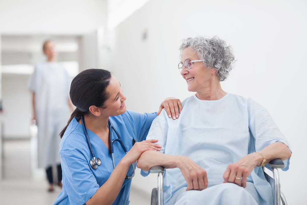 Elderly patient looking at a nurse in hospital ward Elderly patient looking at a nurse in hospital ward