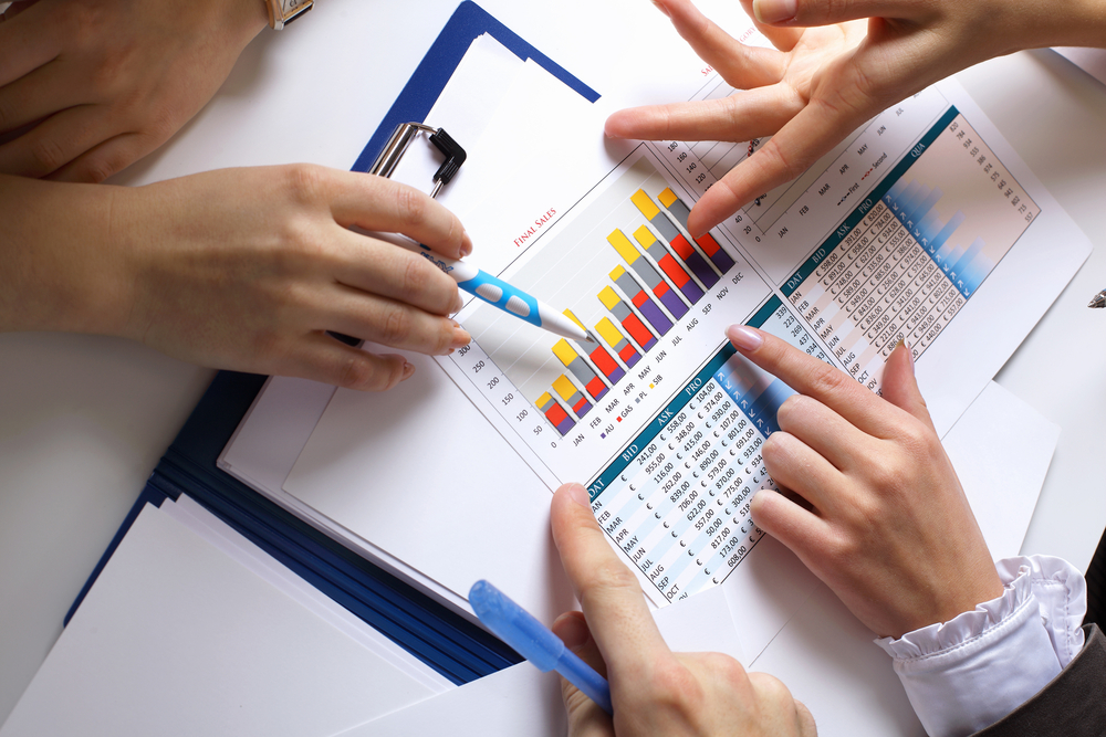 Financial paper charts and graphs on the table Financial paper charts and graphs on the table